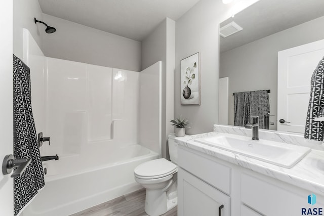 full bathroom with vanity, toilet, hardwood / wood-style flooring, and shower / tub combination