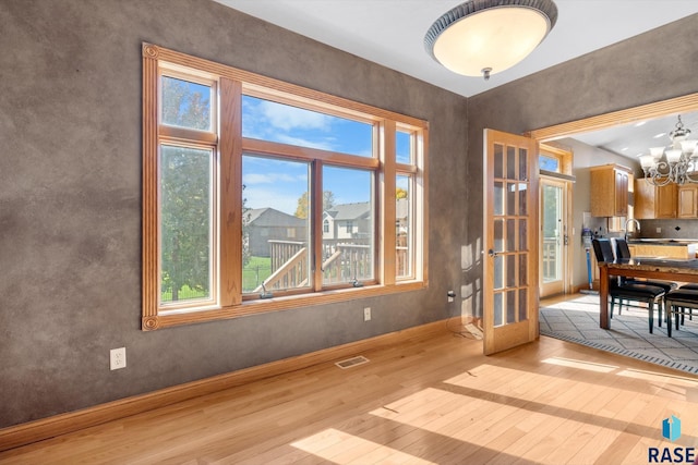 doorway featuring light hardwood / wood-style floors, a notable chandelier, and sink