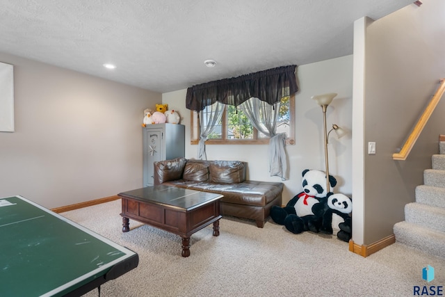 carpeted living room featuring a textured ceiling