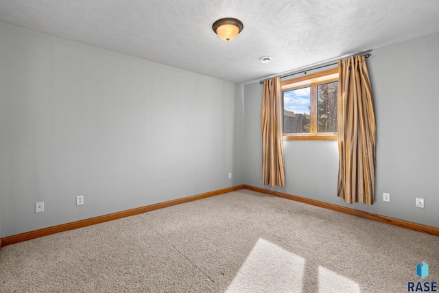 carpeted empty room featuring a textured ceiling