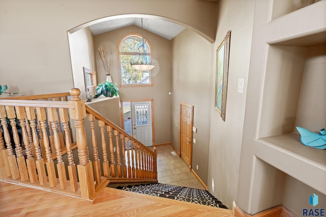 entryway with vaulted ceiling and light tile patterned floors