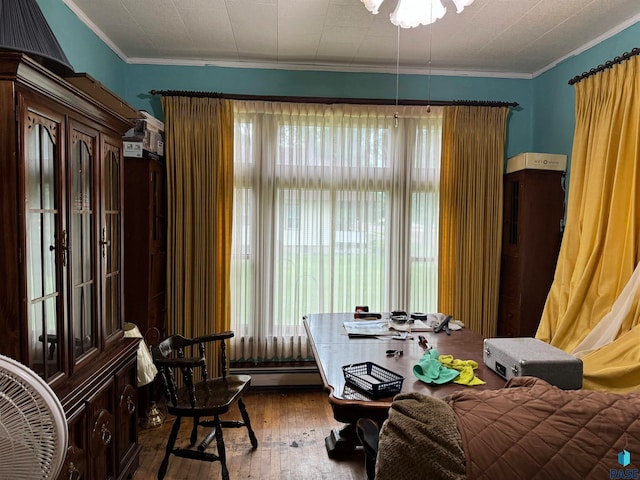 living area with ornamental molding, a baseboard heating unit, and hardwood / wood-style floors