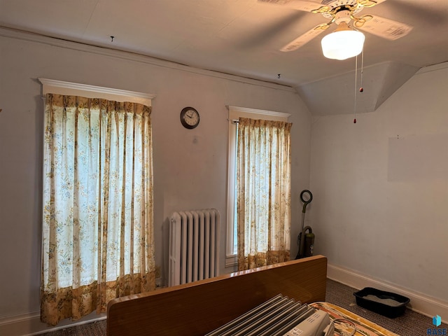 unfurnished bedroom featuring carpet floors, ceiling fan, radiator, and vaulted ceiling