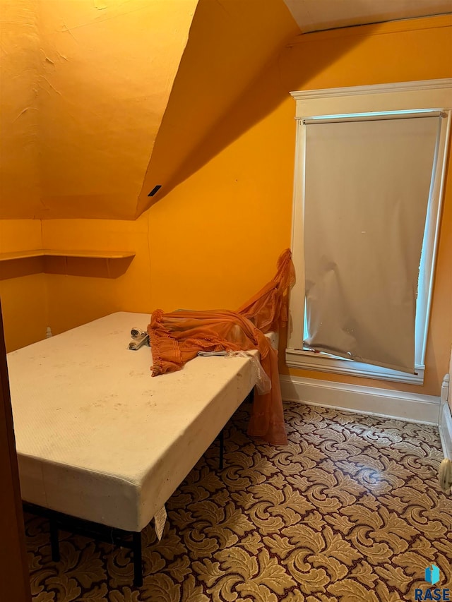 bedroom featuring lofted ceiling and carpet