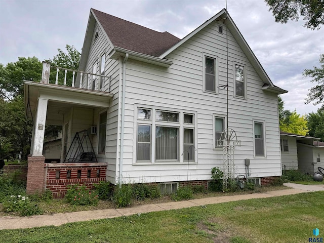 view of property exterior featuring a lawn and a balcony