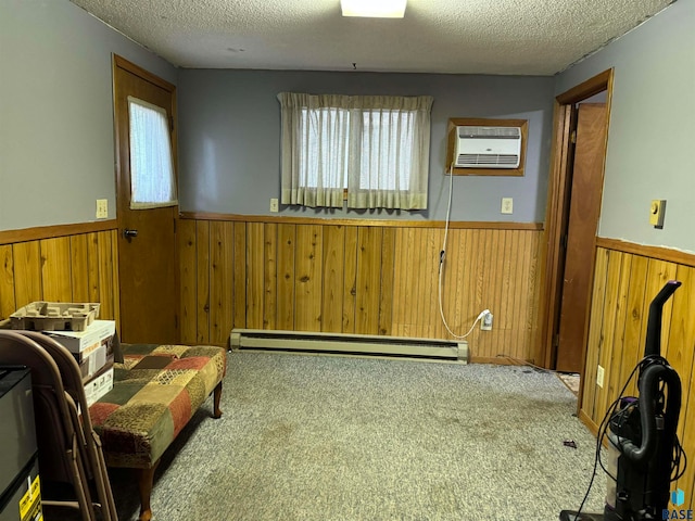 living area featuring wooden walls, a wall mounted AC, a textured ceiling, and baseboard heating