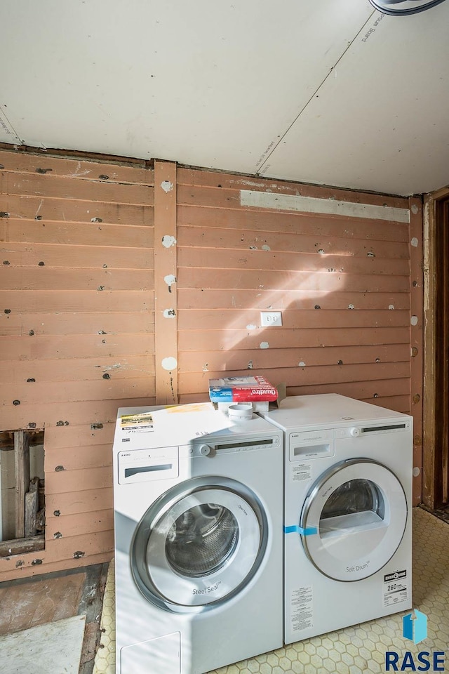 washroom with separate washer and dryer and wood walls