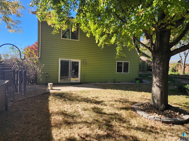 rear view of property featuring a yard and a patio