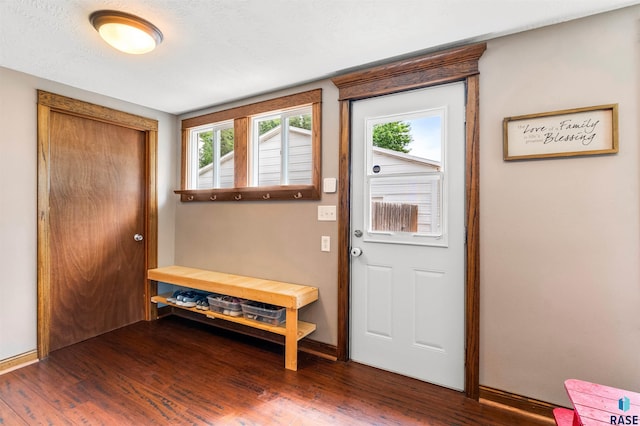 doorway to outside with dark hardwood / wood-style flooring and a textured ceiling