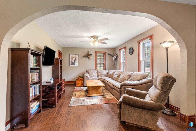 living room featuring dark hardwood / wood-style flooring and ceiling fan