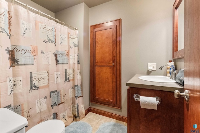 bathroom featuring vanity, tile patterned flooring, and toilet