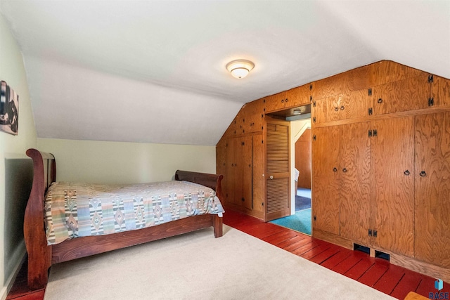 bedroom with dark hardwood / wood-style floors and vaulted ceiling