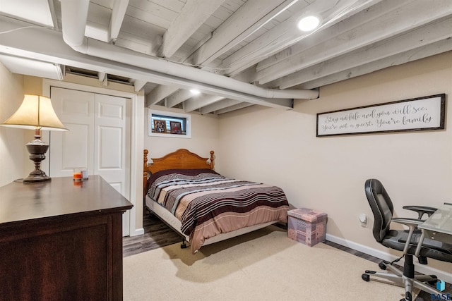 carpeted bedroom with beam ceiling