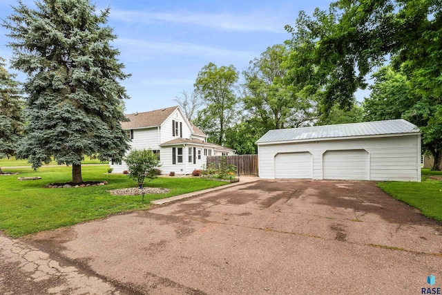 exterior space featuring a garage, an outdoor structure, and a front yard