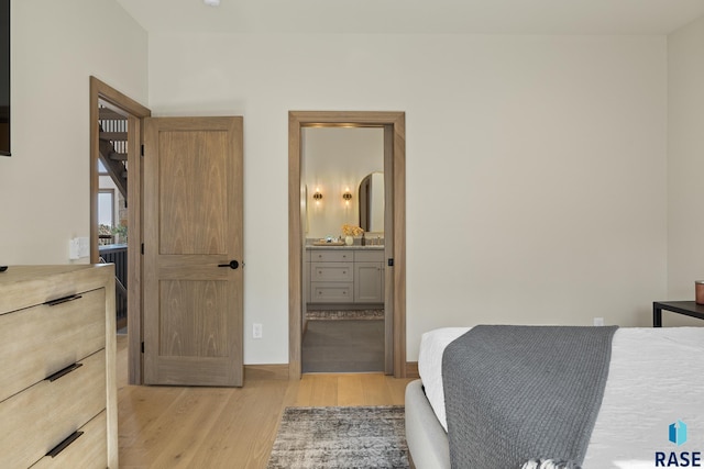 bedroom featuring light hardwood / wood-style floors and ensuite bath