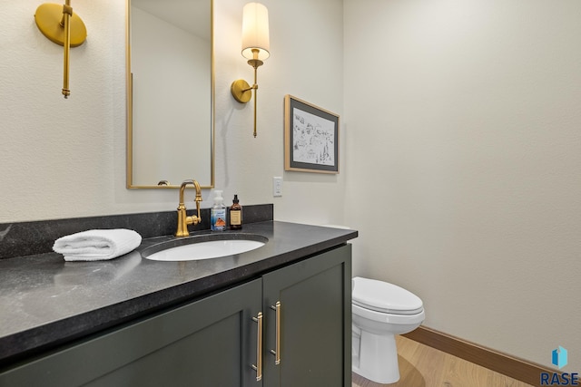 bathroom featuring toilet, hardwood / wood-style floors, and vanity