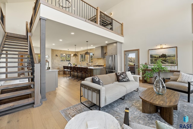 living room featuring a towering ceiling and light wood-type flooring