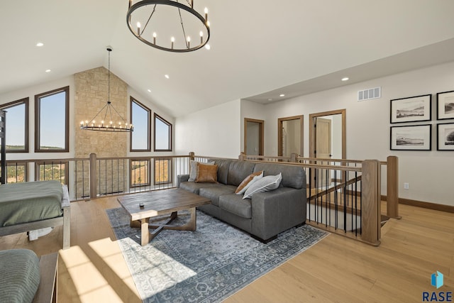 living room featuring light hardwood / wood-style floors, an inviting chandelier, and high vaulted ceiling