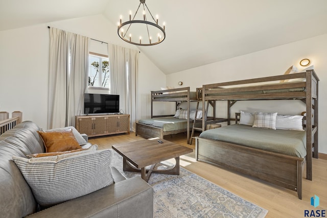 bedroom featuring an inviting chandelier, light wood-type flooring, and vaulted ceiling