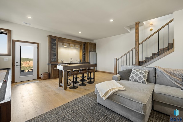 living room featuring sink, decorative columns, and light hardwood / wood-style flooring