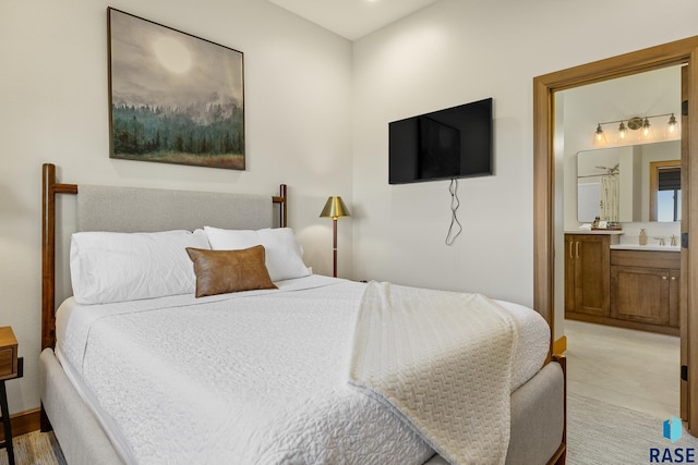 carpeted bedroom featuring connected bathroom and sink