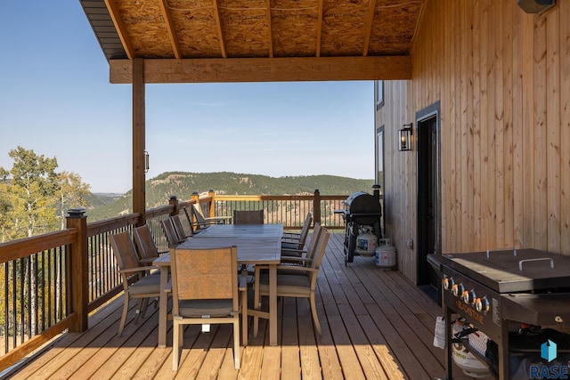 wooden terrace featuring a mountain view and a grill