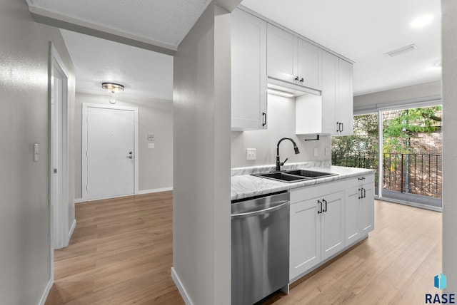 kitchen with sink, dishwasher, white cabinetry, light stone counters, and light hardwood / wood-style flooring