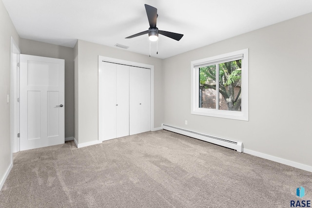 unfurnished bedroom featuring a closet, ceiling fan, a baseboard radiator, and light colored carpet