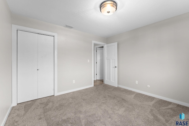 unfurnished bedroom with a closet and carpet floors