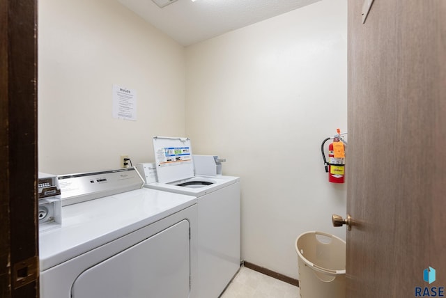 clothes washing area featuring washer and clothes dryer and a textured ceiling