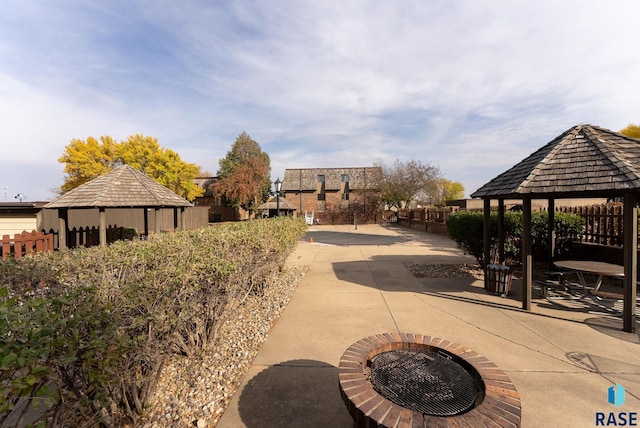 view of home's community with a gazebo, an outdoor fire pit, and a patio area