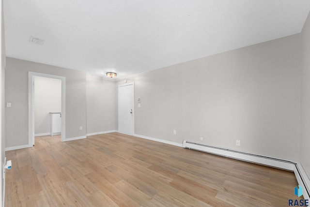 spare room featuring a baseboard radiator and light wood-type flooring