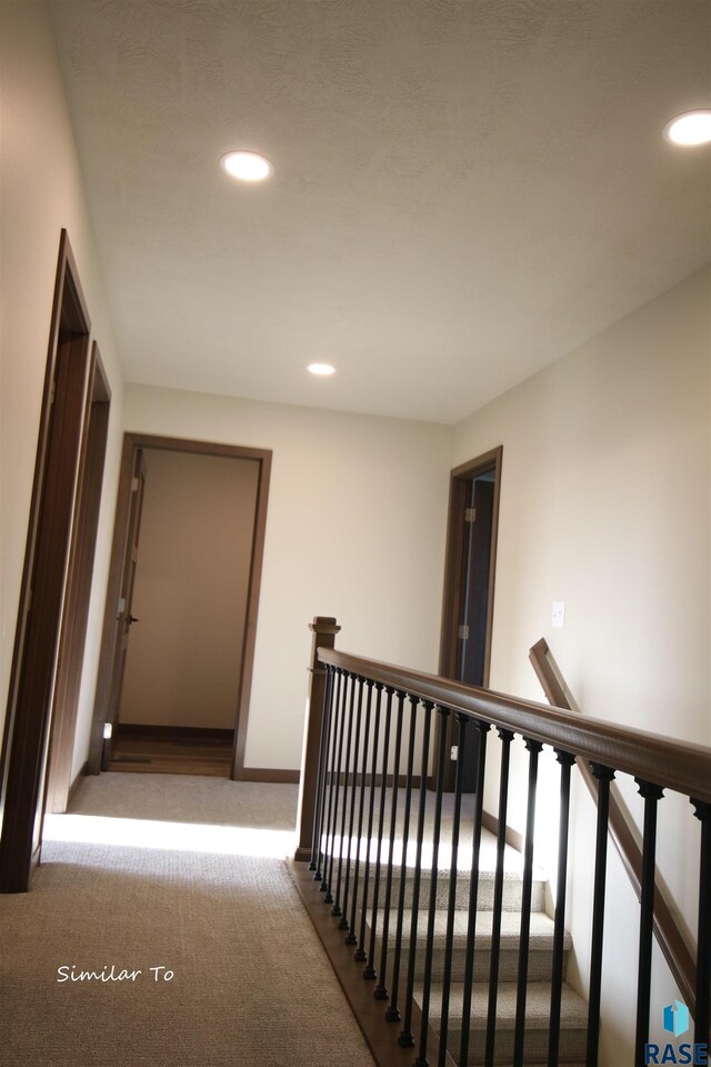 hallway with light colored carpet