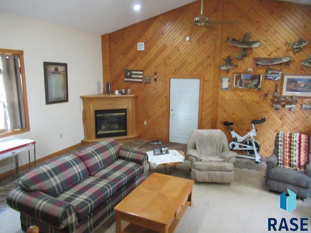 living room featuring ceiling fan, wood walls, and a towering ceiling