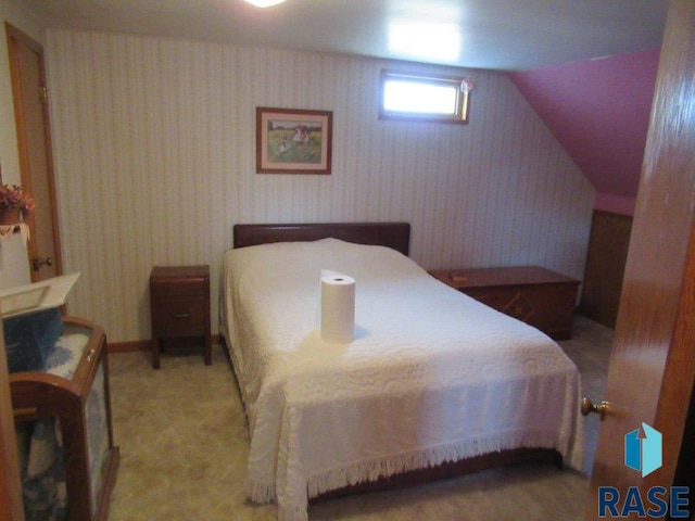 bedroom featuring lofted ceiling and light colored carpet