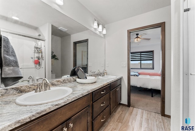 bathroom featuring vanity, toilet, hardwood / wood-style flooring, and ceiling fan