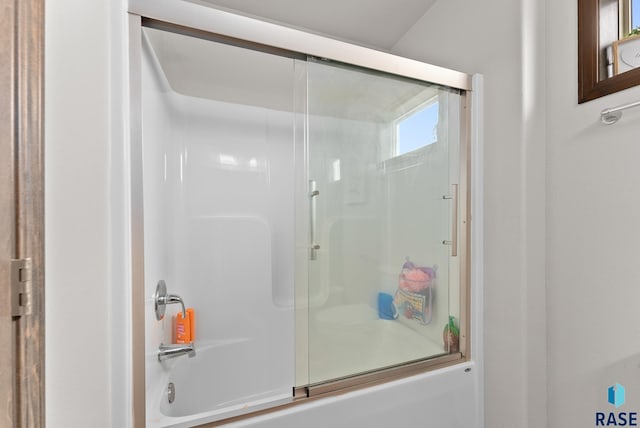 bathroom featuring bath / shower combo with glass door