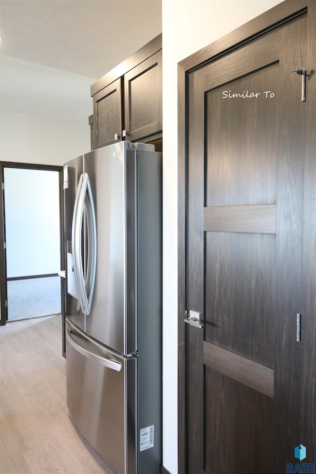 kitchen with light wood-type flooring and stainless steel fridge