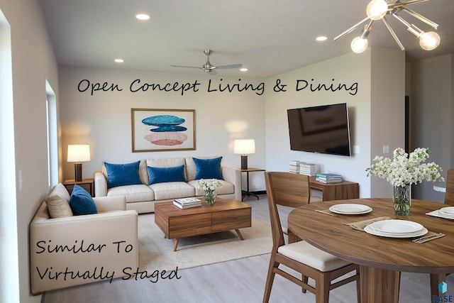 living room with ceiling fan with notable chandelier and light wood-type flooring