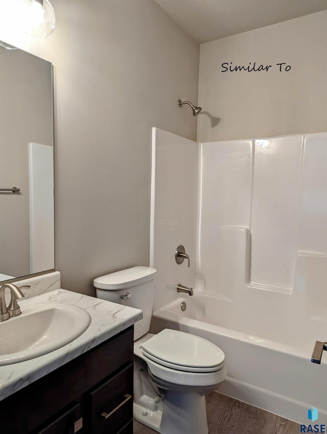 full bathroom featuring toilet, hardwood / wood-style flooring,  shower combination, and vanity