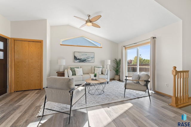 living room featuring lofted ceiling, hardwood / wood-style flooring, and ceiling fan