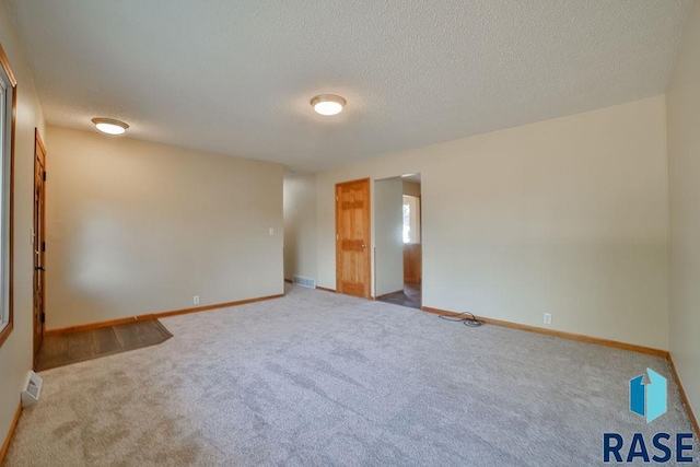 unfurnished room featuring carpet floors and a textured ceiling