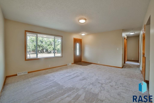 carpeted spare room featuring a textured ceiling