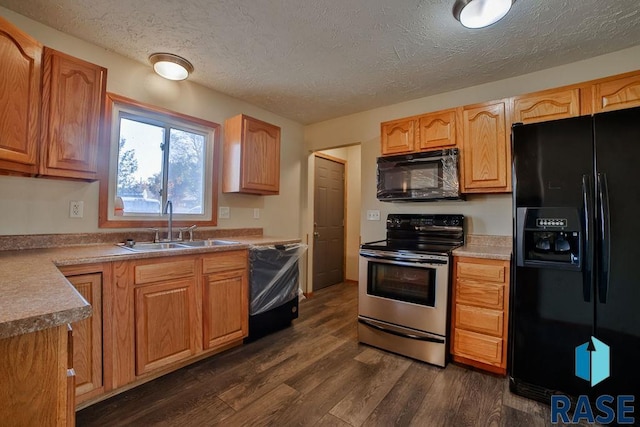 kitchen featuring sink, a textured ceiling, black appliances, and dark hardwood / wood-style flooring