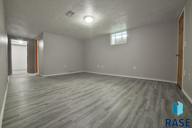 empty room with wood-type flooring and a textured ceiling