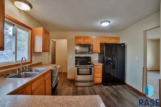 kitchen with sink, dark wood-type flooring, black appliances, and a textured ceiling