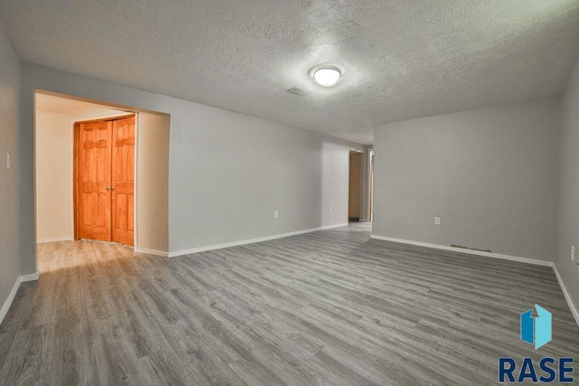 empty room featuring wood-type flooring and a textured ceiling