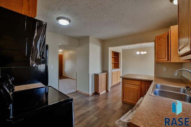 kitchen with dark hardwood / wood-style floors, decorative light fixtures, black electric range oven, sink, and a textured ceiling