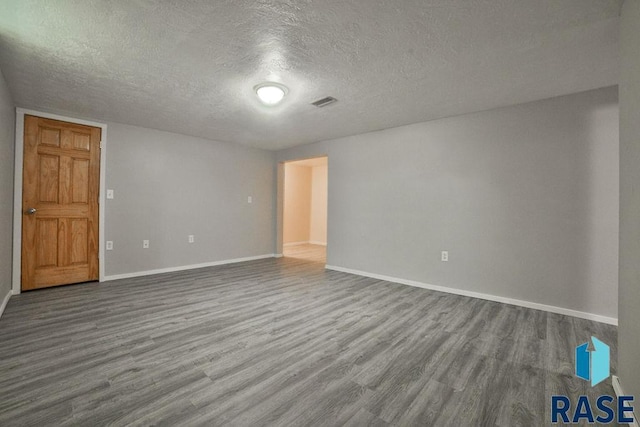 unfurnished room featuring hardwood / wood-style flooring and a textured ceiling