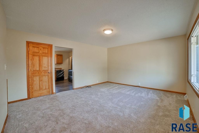 carpeted spare room with a textured ceiling